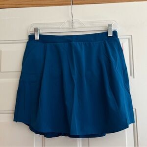 New Women’s Spanx Get Moving 14” teal pull on pleated skort. Size medium.